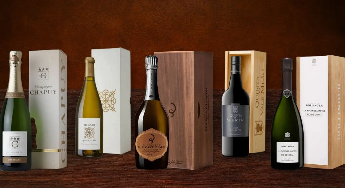 A row of wine gift sets, each bottle beside its own presentation box, including Champagne Chapuy, Billecart-Salmon and Quinta do Vale Meao Port